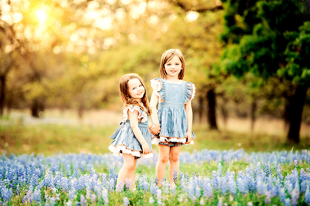 two little girls in bluebonnet field in texas hill country