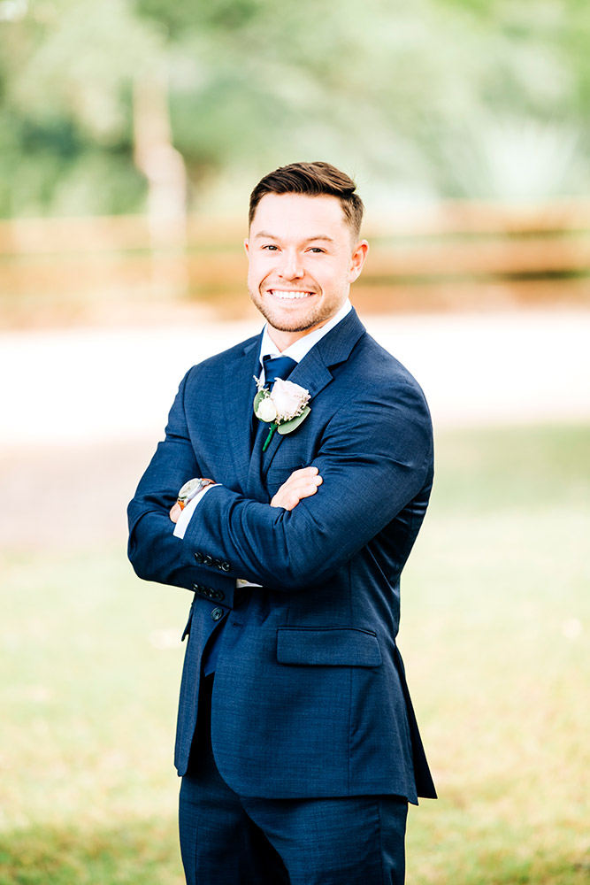 groom in navy blue suit in texas hill country